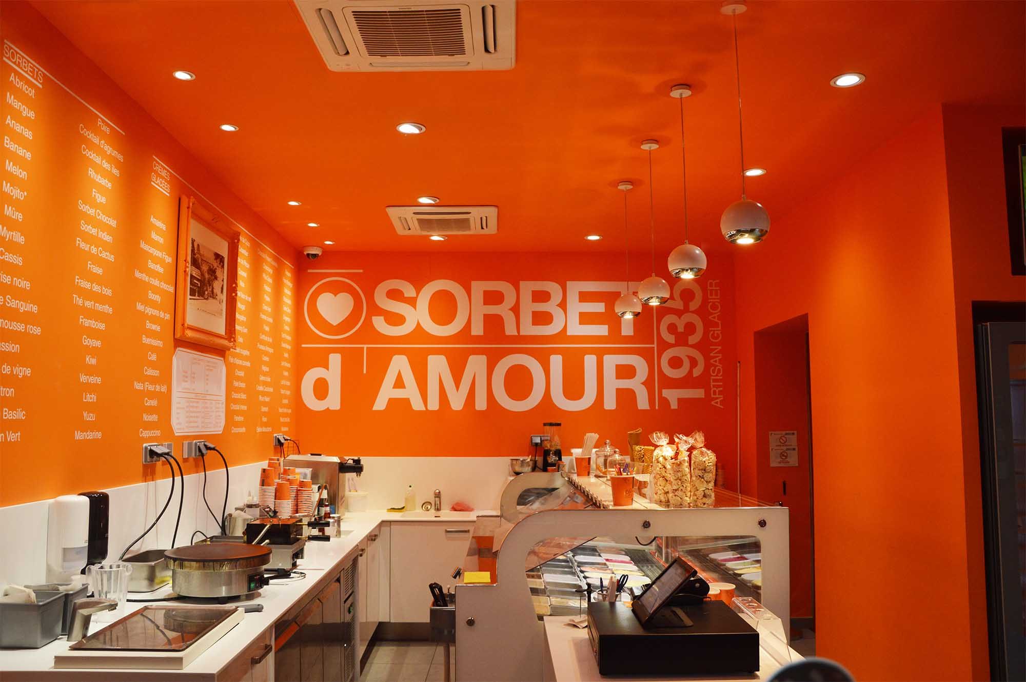 Vue intérieure de la boutique Sorbet d'Amour porte Dijeaux : mobilier bois blanc, plan en corian, couleur affirmée.